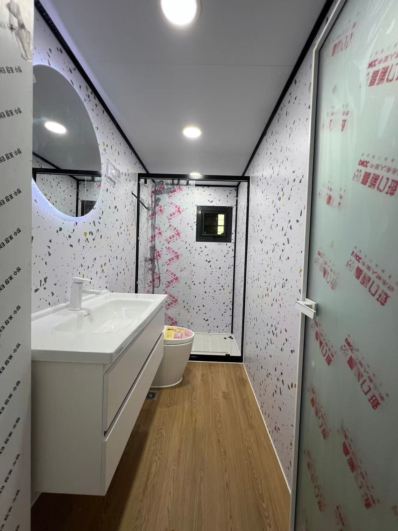 Modern bathroom interior of a 40FT container home with shower, toilet and vanity