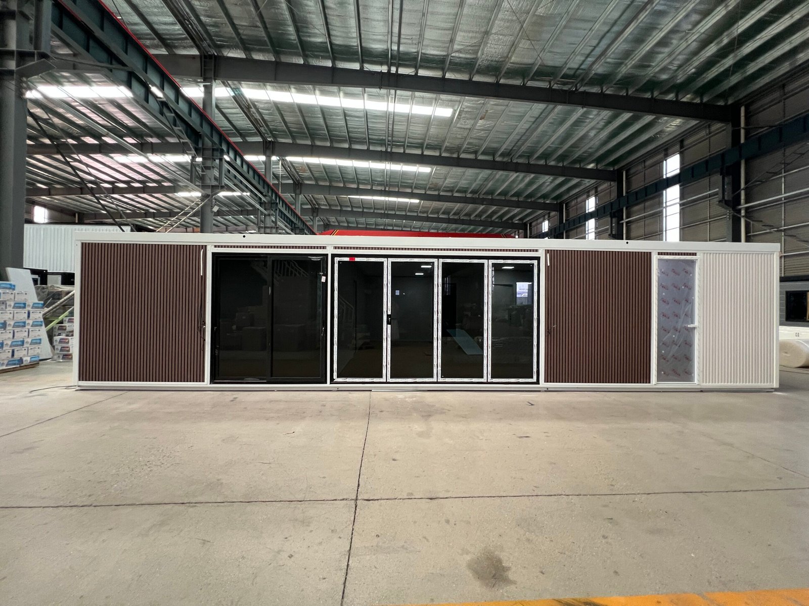 Front view of a 40FT expandable container house with decorative metal siding and large glass windows