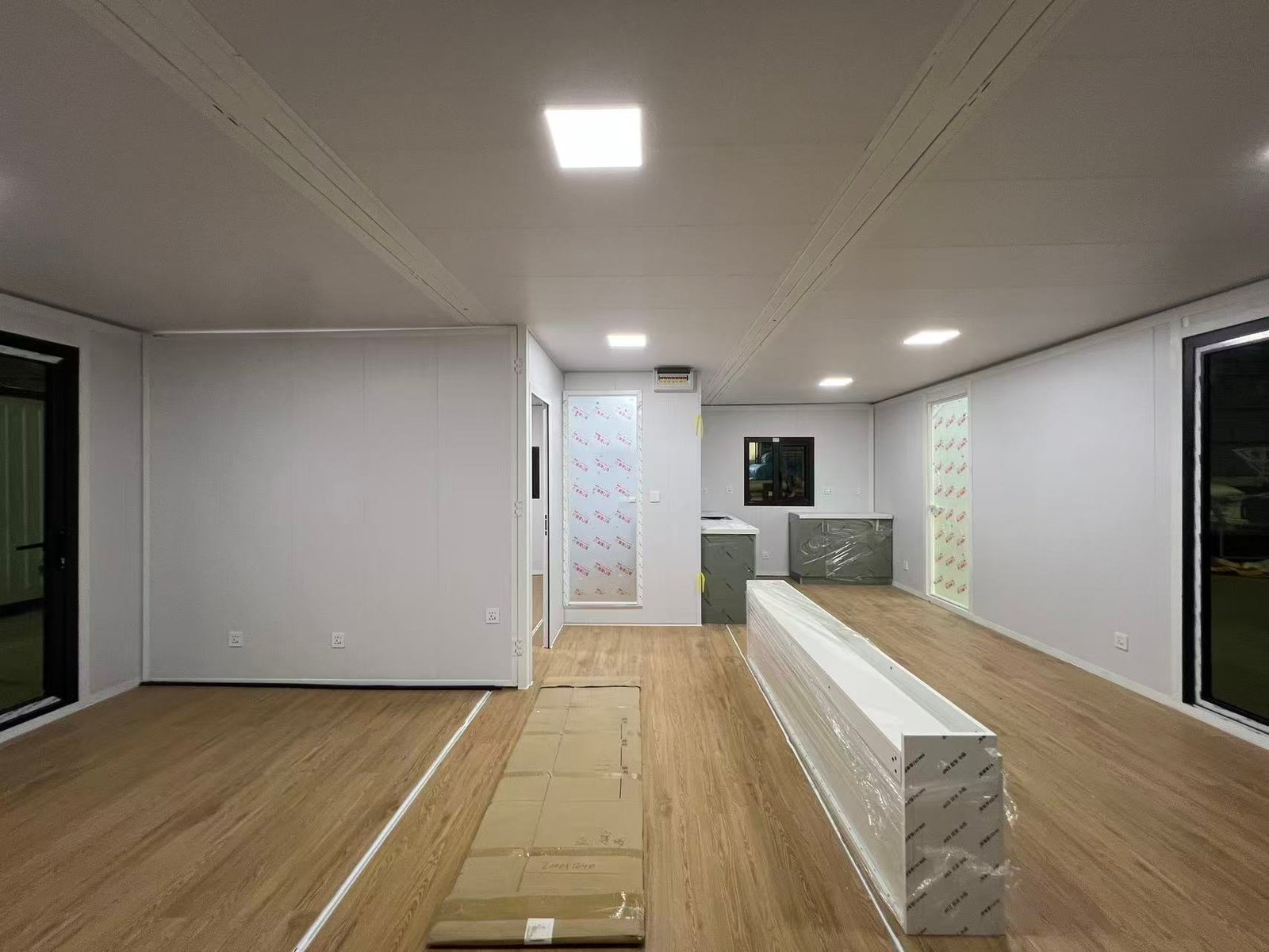 Bright living room inside a 40FT modular home with large windows and abundant natural light