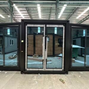 Front view of a gray expandable container house with a full glass facade