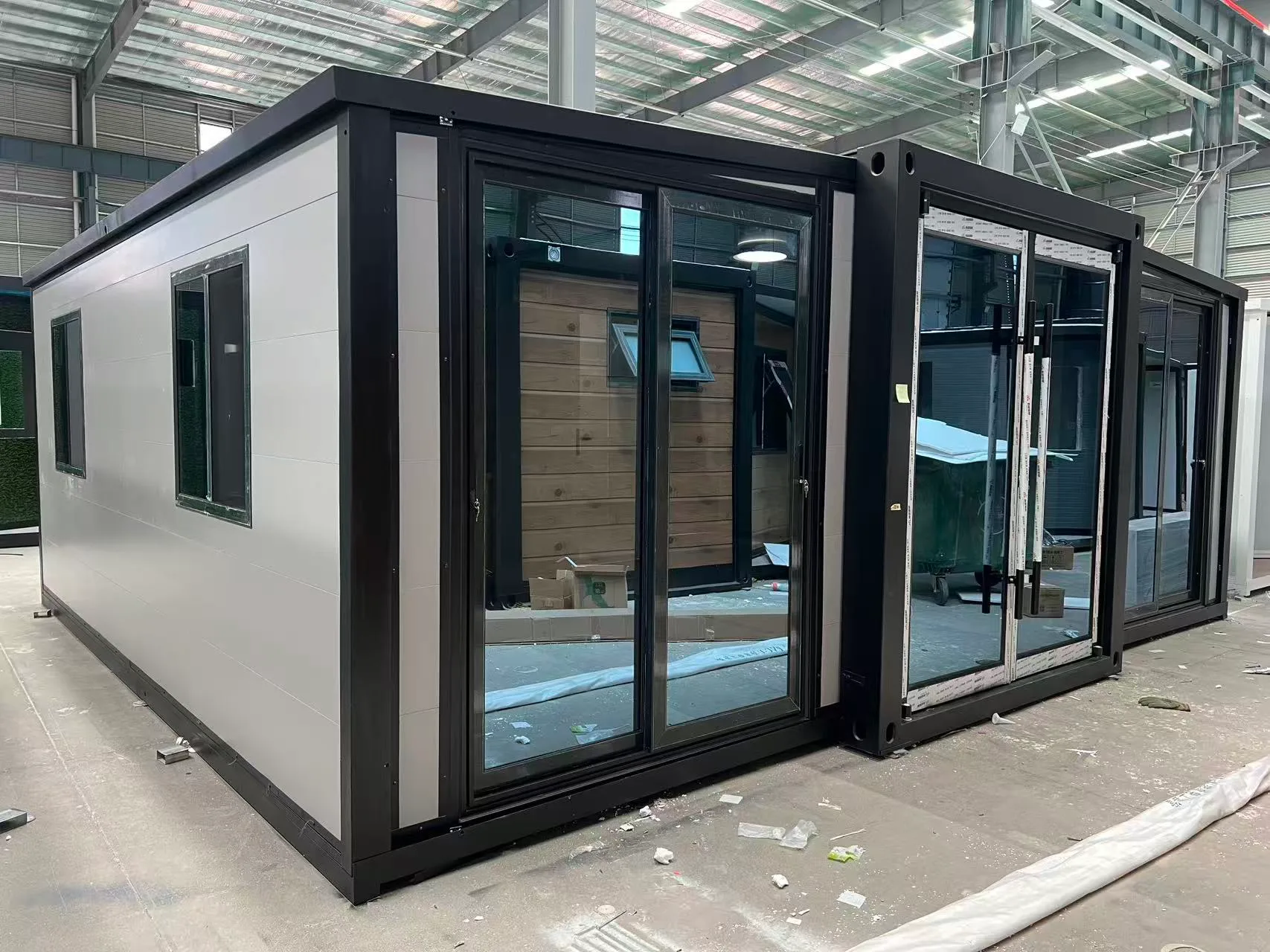 Side view of a gray expandable container home with solid insulated wall panels