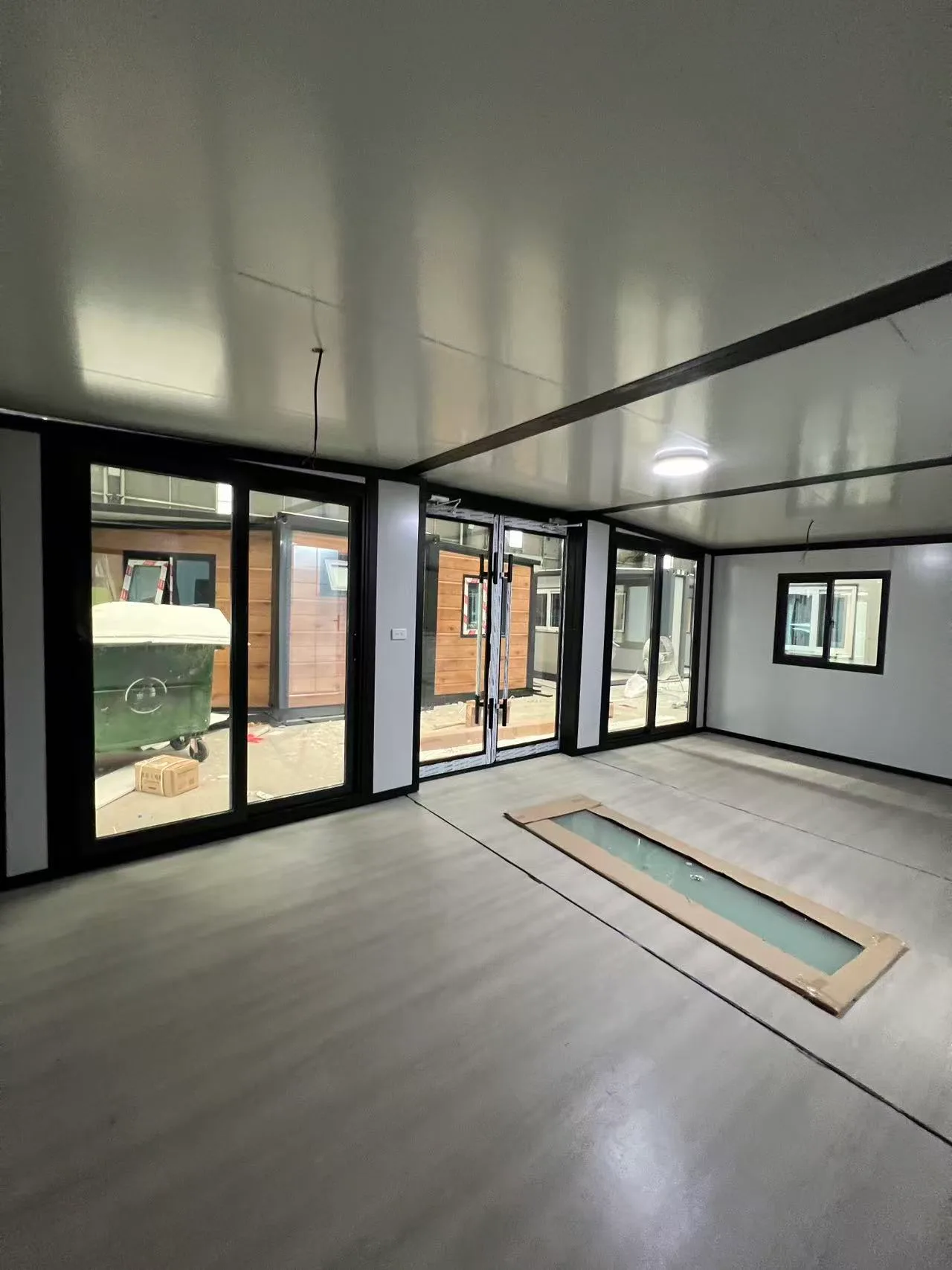 Modern living room inside an expandable modular home with a large glass front wall