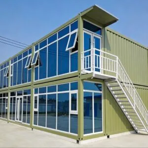 Two-story green prefab container building with exterior staircase