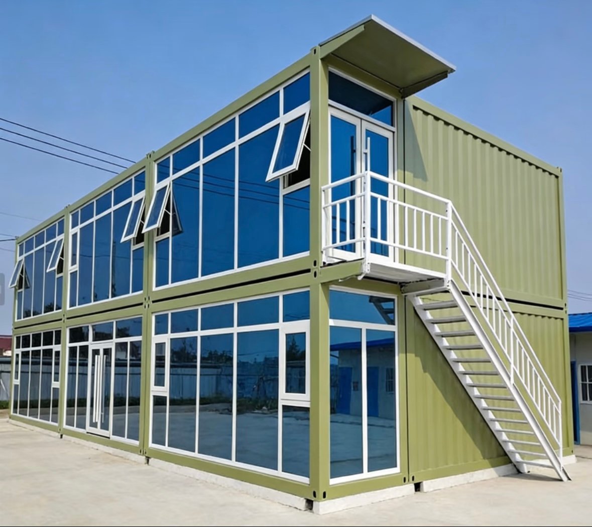 Two-story green prefab container building with exterior staircase