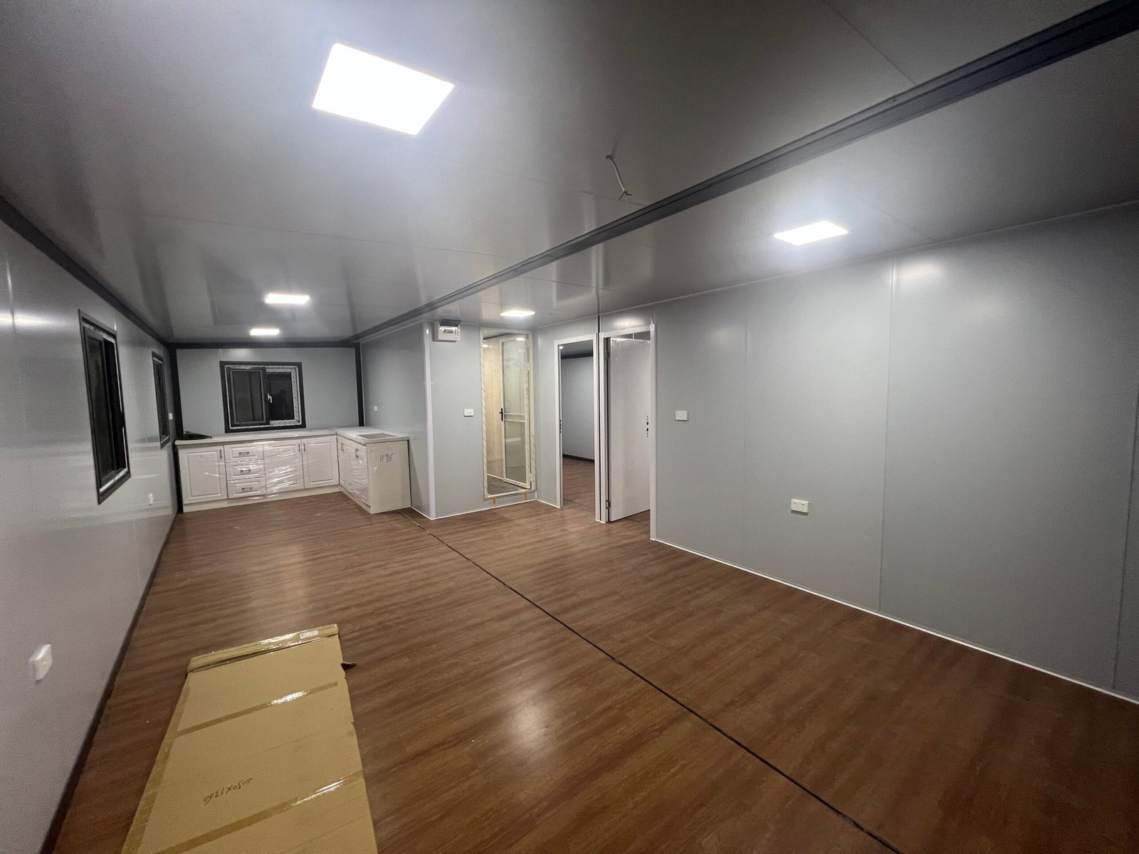 Open kitchen inside wind-resistant expandable container house with modern cabinets and dining area