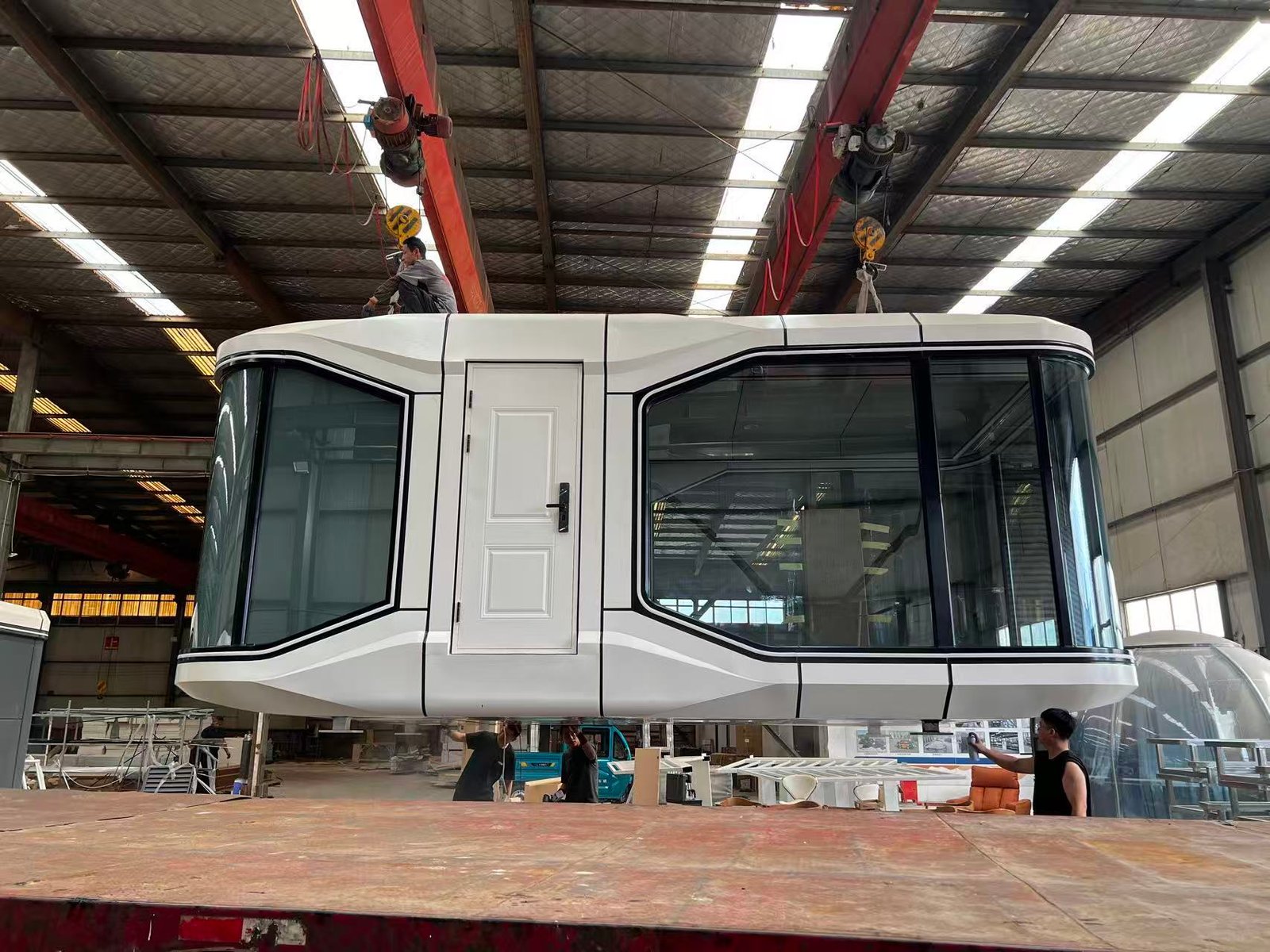 23sqm compact Space Capsule House, small luxury glamping pod being lifted inside manufacturing workshop